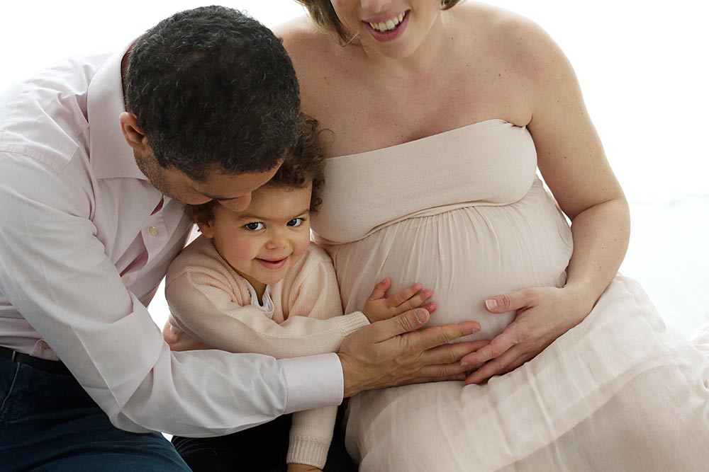 dad and baby wih hands on the pregnant belly